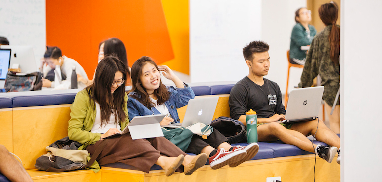 Three students sitting on couch in Moffitt Library