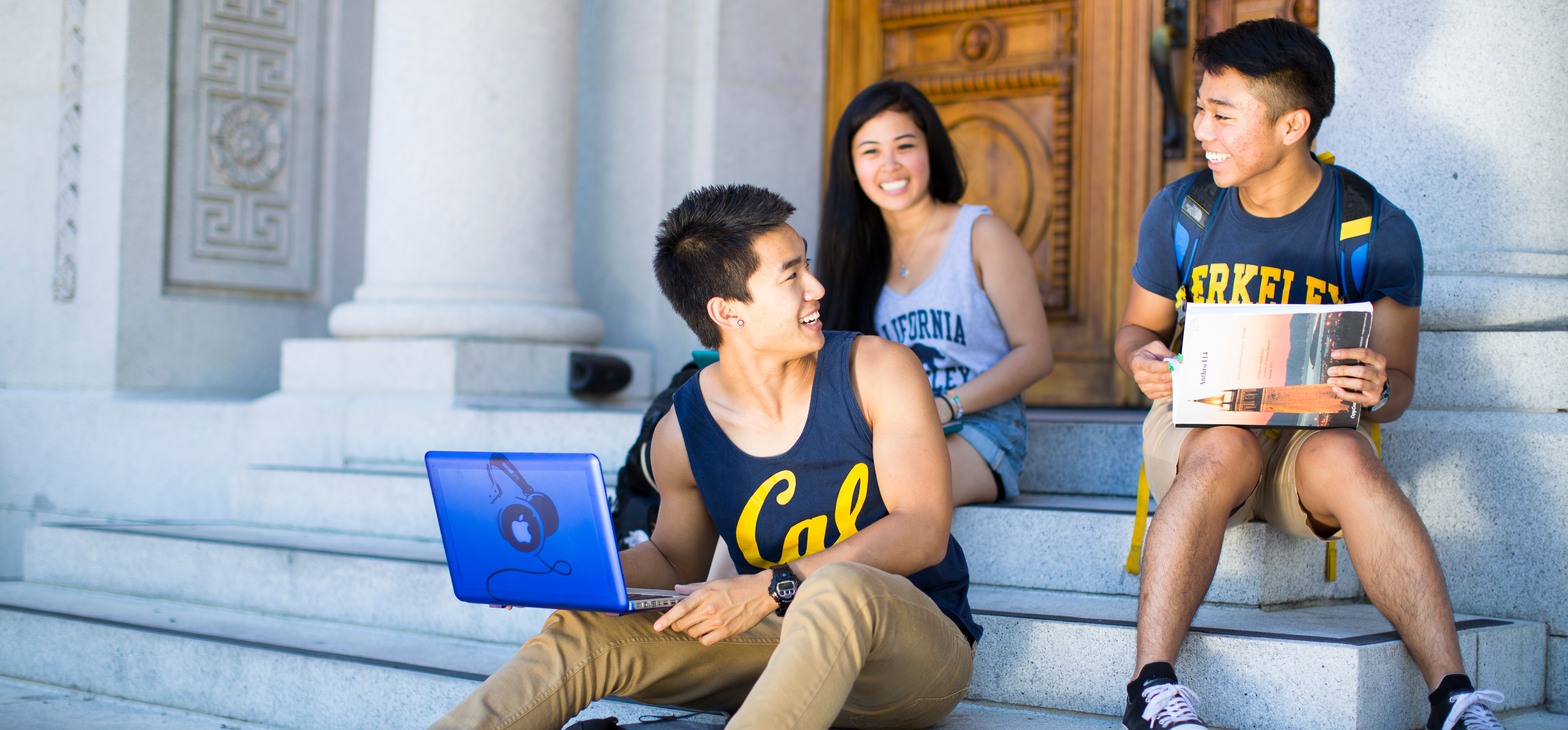 Three students sitting on steps