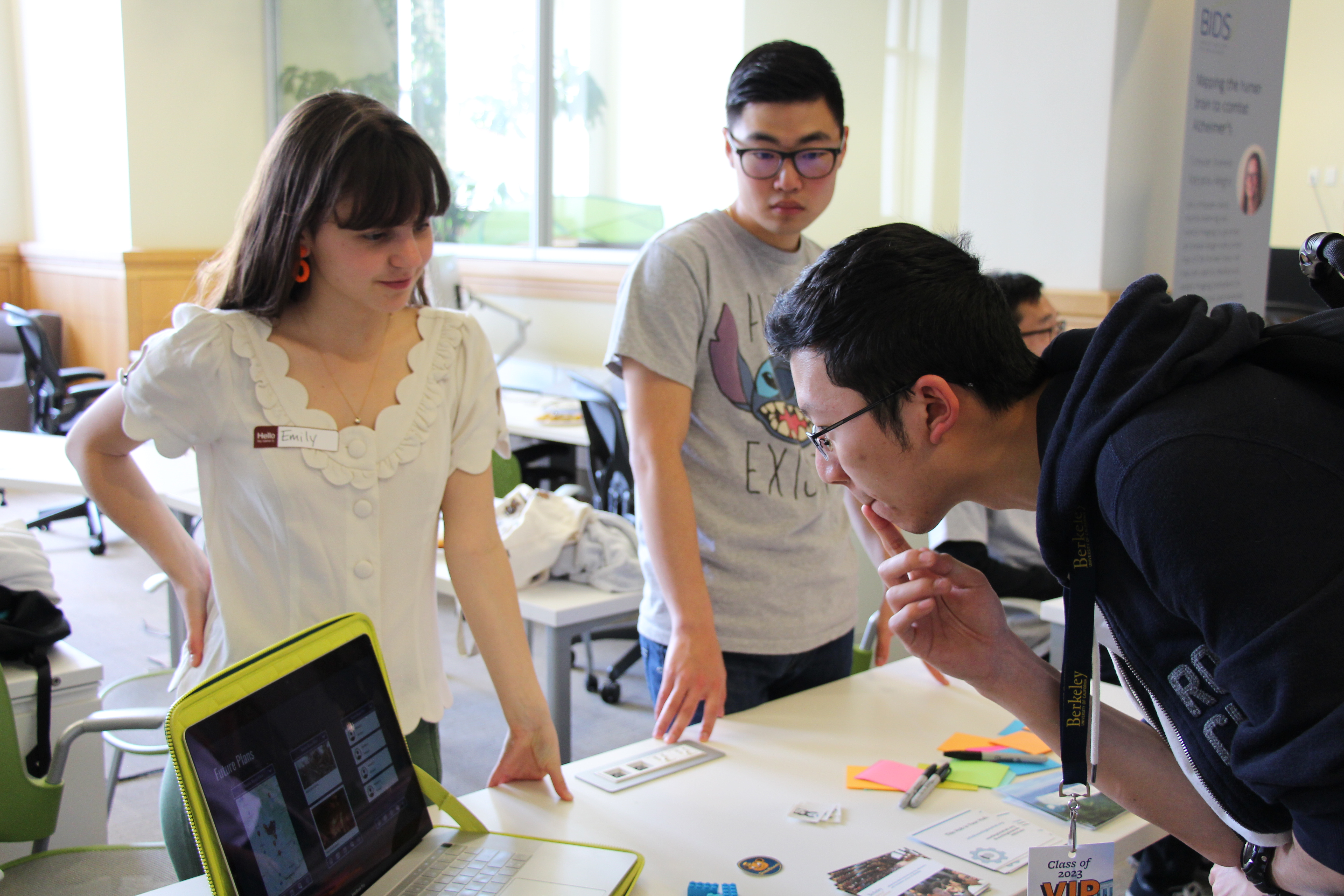 Interested student examines data presented on computer screen while female data science student awaits questions