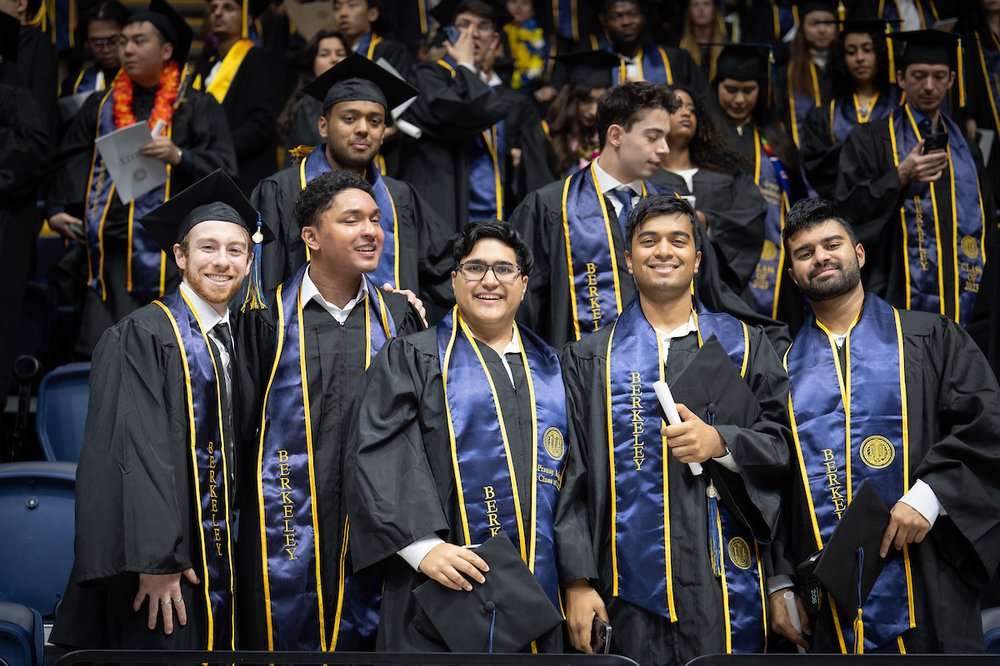 Students dressed in commencement regalia, smiling while posing for a picture at the 2024 UC Berkeley Commencement Ceremony