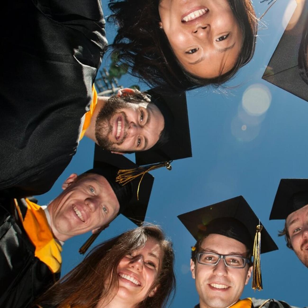 group of graduates looking down at camera