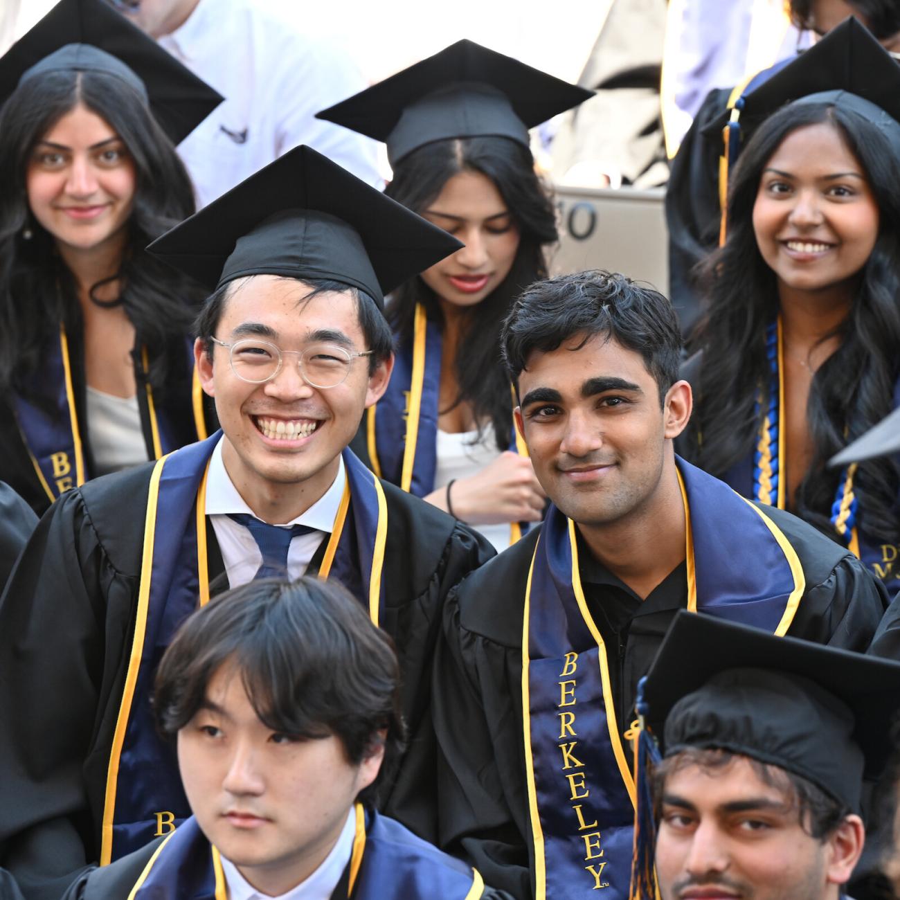 Graduates smile for the photographer, waiting for their commencement to start