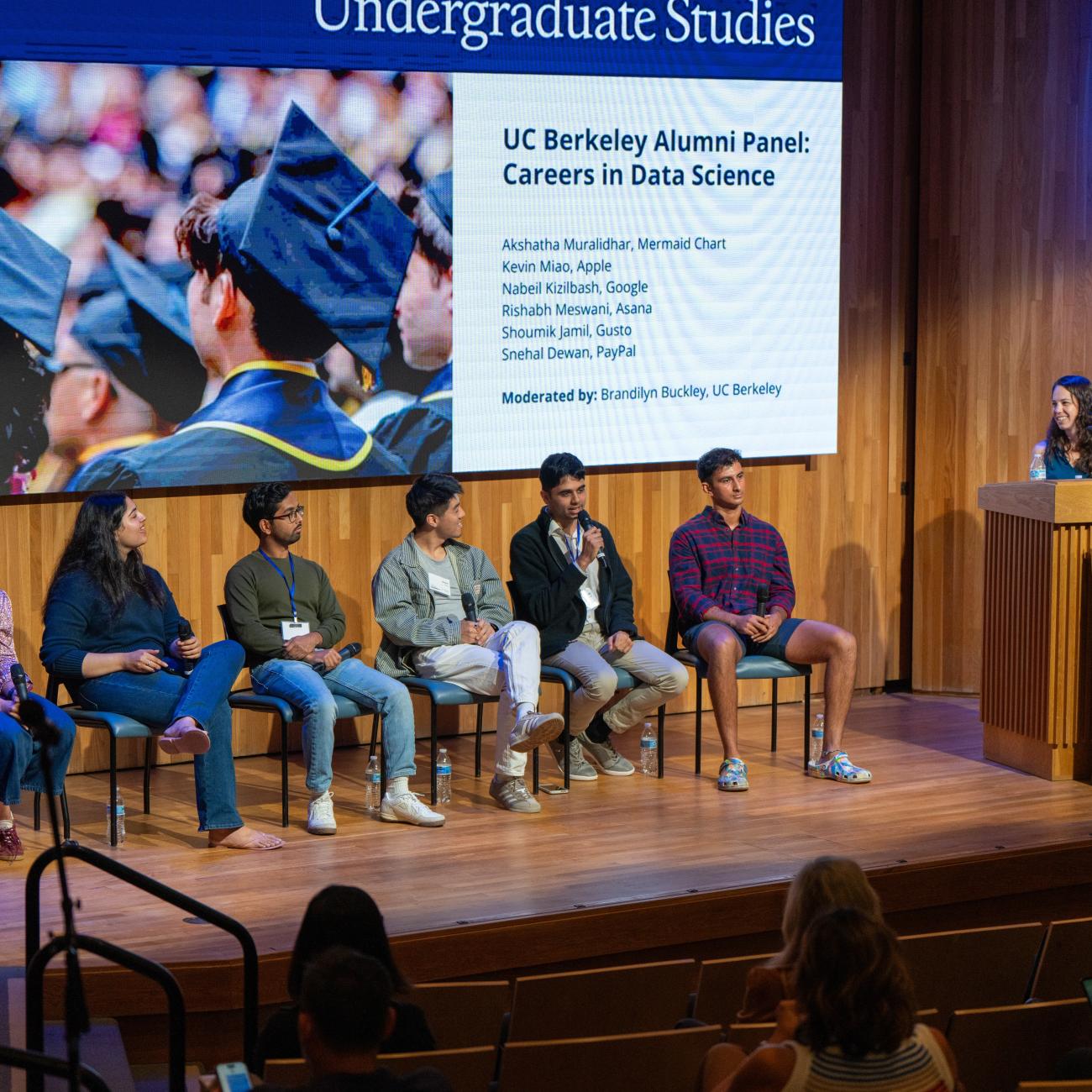 2025 Homecoming panelists listen while alum Rishabh Meswani speaks into the mic