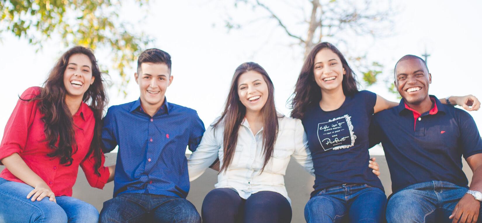 group of five people sitting together and smiling