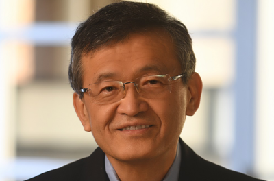 Portrait of Lip-Bu Tan smiling in front of a window 