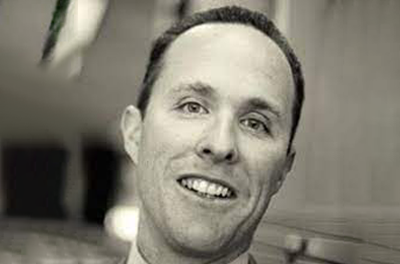 Black and white portrait of Michael Grimes smiling 