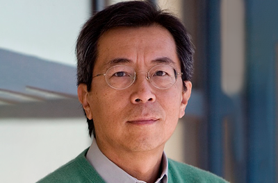 Portrait of Robert Tjian in front of a white and blue wall