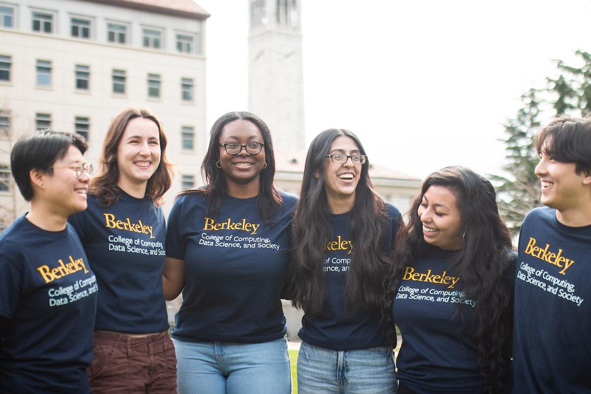 Students smile in front of the Campanile on the UC Berkeley campus.