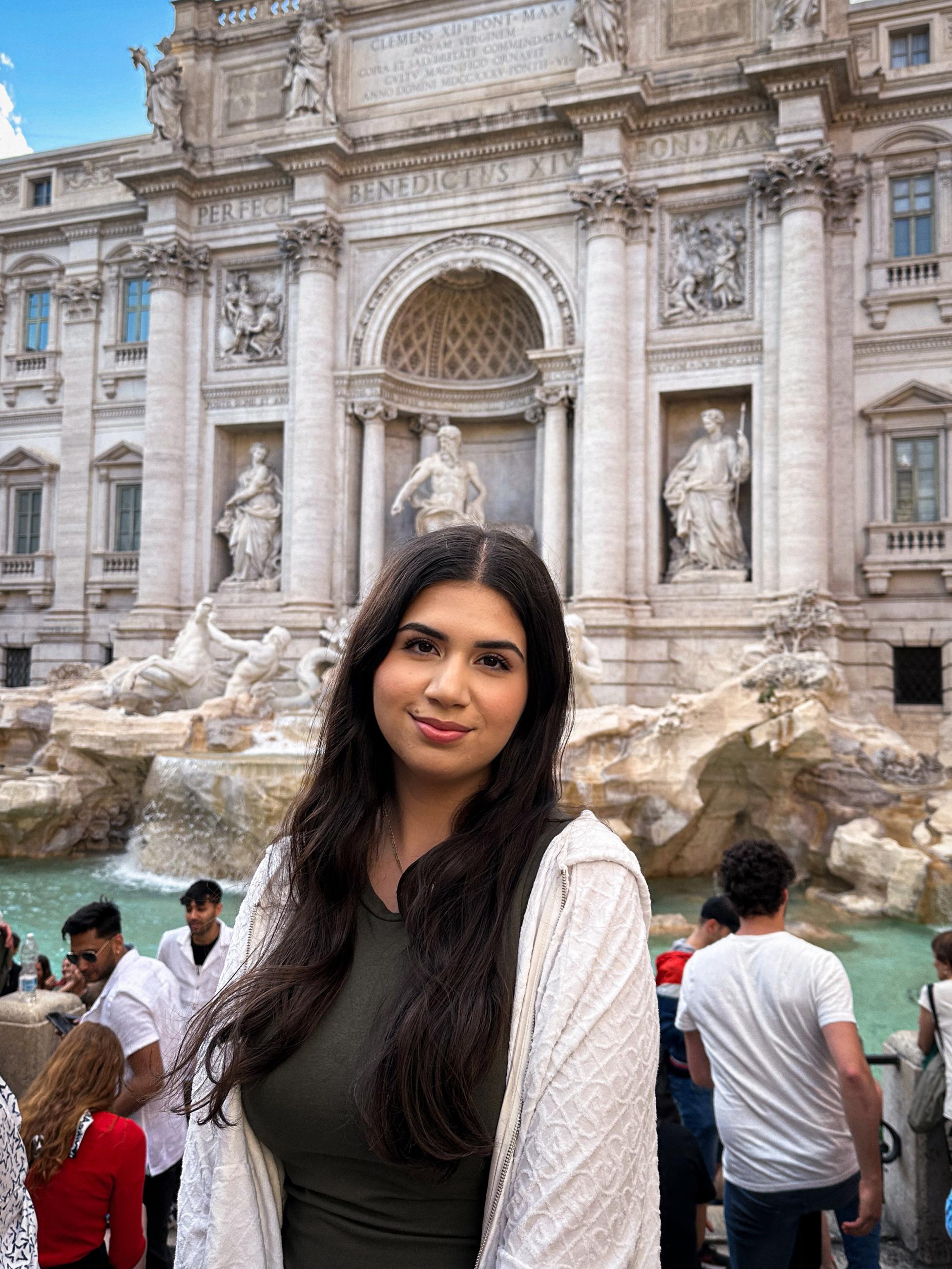 Angela Loza smiling in front of a historic building in Europe