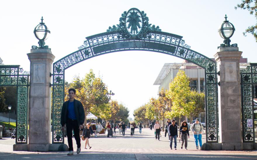 Students walk on UC Berkeley's campus through Sather Gate.