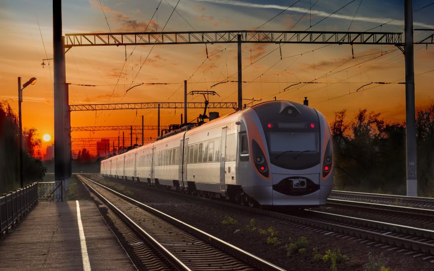 Passenger inter-city train in city on the sunset background